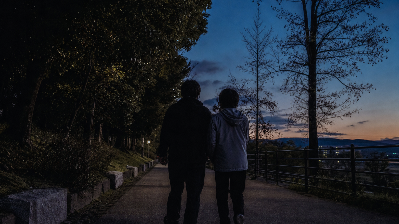 夜明け前の道を並んで歩く二人の後ろ姿